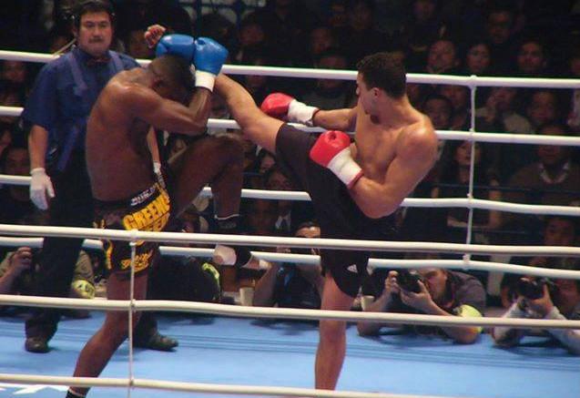 Badr Hari throws a right high roundhouse kick to Remy Bonjasky's guard 